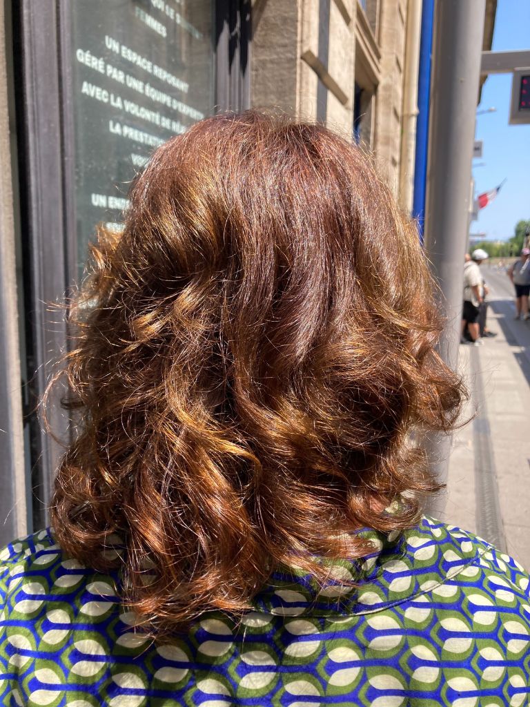 femme de dos, coupe de cheveux mi-long et ondulés, mèches en coloration végétale