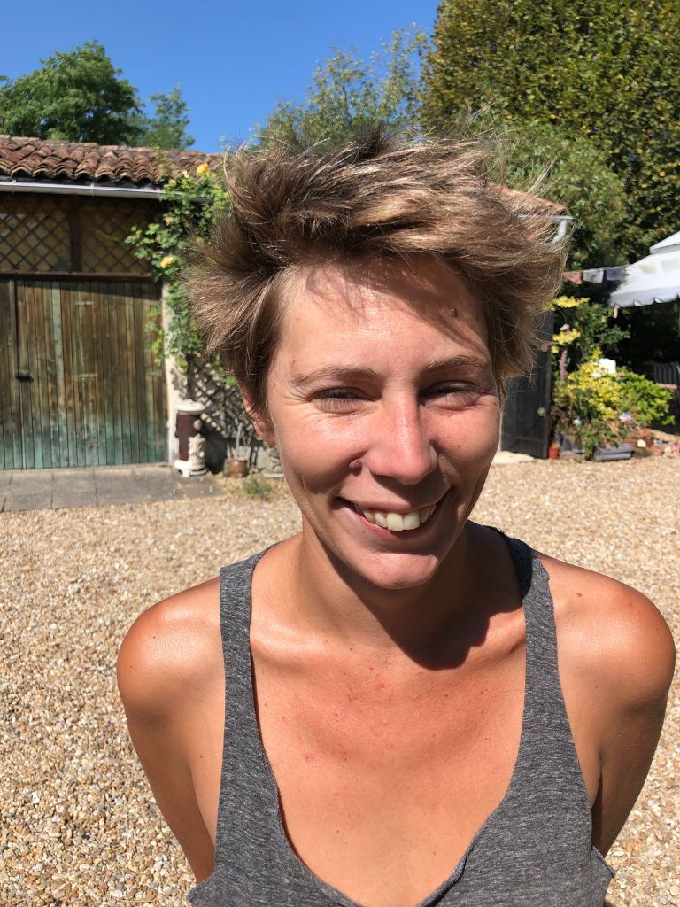 portrait d'une femme souriante après une coupe courte de cheveux
