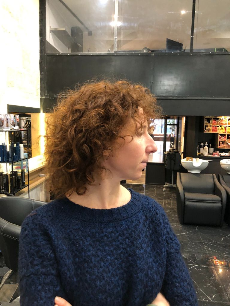 profil d'une femme aux cheveux mi-longs bouclés