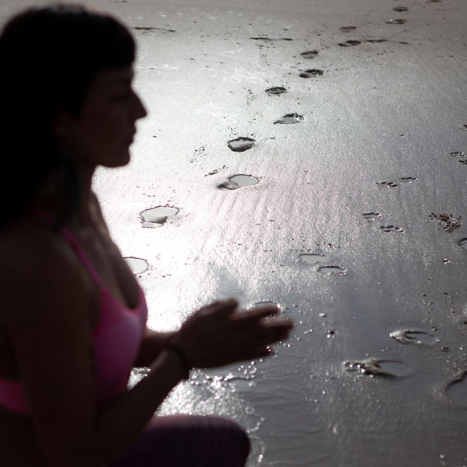 femme de profil qui médite à la plage